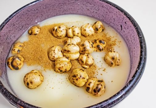 traditional turkish drink boza in glass with cinnamon powder and roasted chickpeas