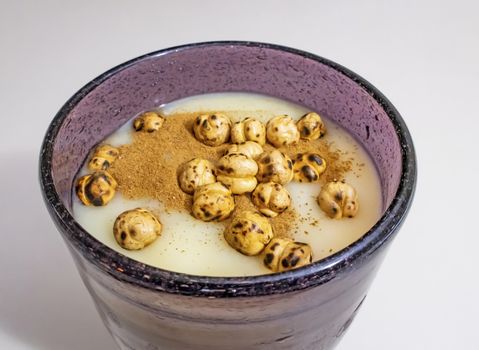 traditional turkish drink boza in glass with cinnamon powder and roasted chickpeas