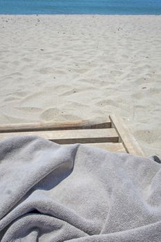 wooden sun lounger chair for sunbathing on the beach