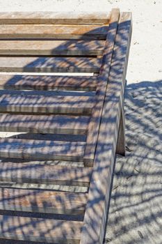 wooden sun lounger chair for sunbathing on the beach