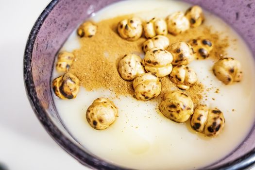 traditional turkish drink boza in glass with cinnamon powder and roasted chickpeas