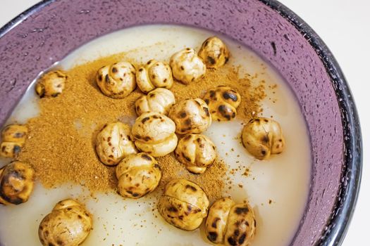 traditional turkish drink boza in glass with cinnamon powder and roasted chickpeas