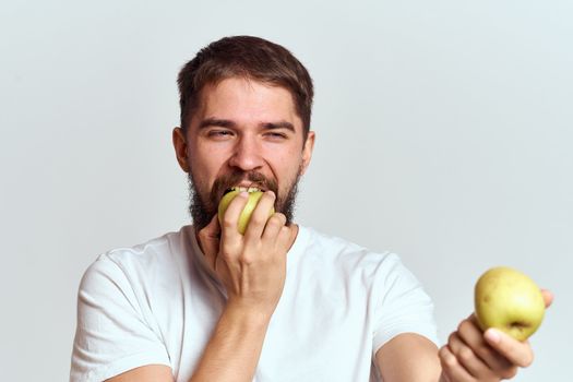 Energetic man with apples health vitamins diet and lifestyle white t-shirt cropped view. High quality photo