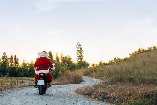 santa claus riding a motorcycle on the road.