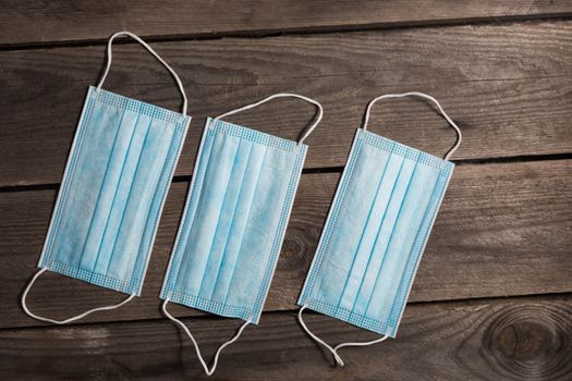 .Blue Medical masks on dark wooden background.