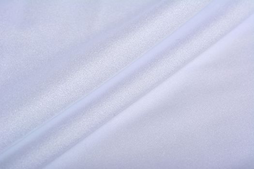 white Knitted elastic fabric, weaving of threads texture, crumpled fold. For underwear, sports clothes and swimwear. Space for text.