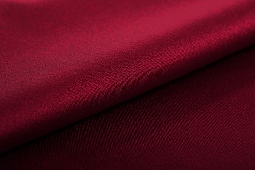 red Knitted elastic fabric, weaving of threads texture, crumpled fold. For underwear, sports clothes and swimwear. Space for text.