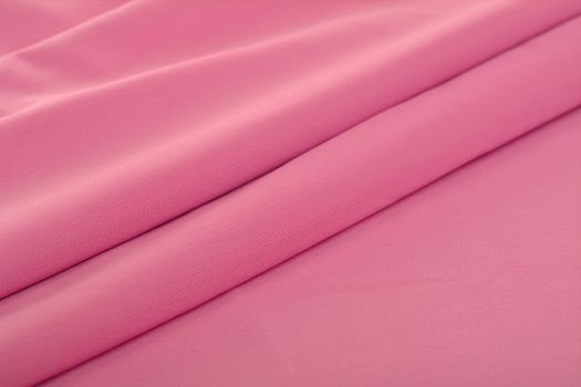 pink Knitted elastic fabric, weaving of threads texture, crumpled fold. For underwear, sports clothes and swimwear. Space for text.