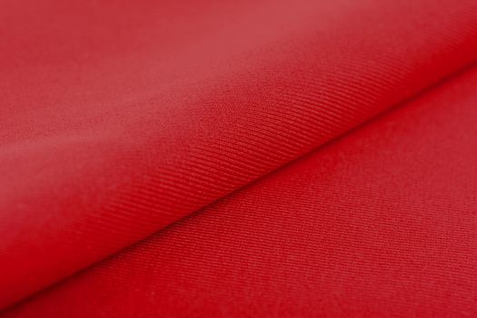 red Knitted elastic fabric, weaving of threads texture, crumpled fold. For underwear, sports clothes and swimwear. Space for text.
