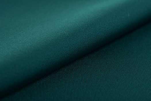 green Knitted elastic fabric, weaving of threads texture, crumpled fold. For underwear, sports clothes and swimwear. Space for text.