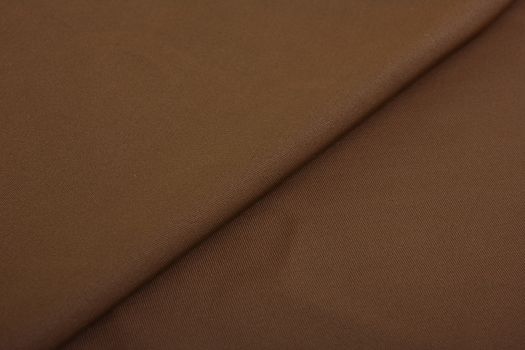 brown Knitted elastic fabric, weaving of threads texture, crumpled fold. For underwear, sports clothes and swimwear. Space for text.