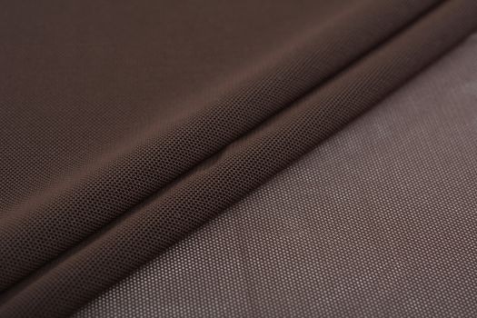 brown Knitted elastic fabric, weaving of threads texture, crumpled fold. For underwear, sports clothes and swimwear. Space for text.