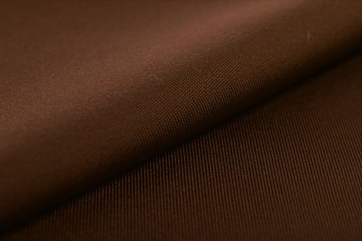 brown Knitted elastic fabric, weaving of threads texture, crumpled fold. For underwear, sports clothes and swimwear. Space for text.