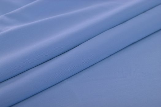 blue Knitted elastic fabric, weaving of threads texture, crumpled fold. For underwear, sports clothes and swimwear. Space for text.