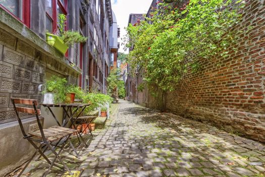 Old street with chair and plants in Liege, Belgium