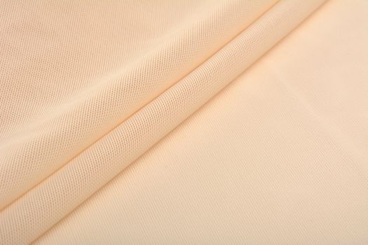 beige Knitted elastic fabric, weaving of threads texture, crumpled fold. For underwear, sports clothes and swimwear. Space for text.