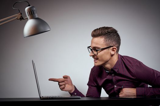 businessman in glasses and a shirt sits at a table with open laptops Coffee Space mobile phone. High quality photo