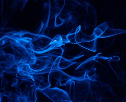 Conceptual image of blue color smoke isolated on dark black background, Halloween concept design element.