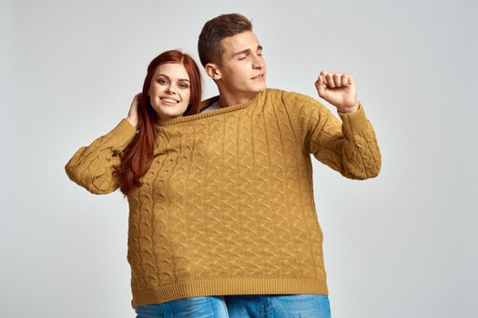 couple in yellow sweater posing against light background cropped view. High quality photo