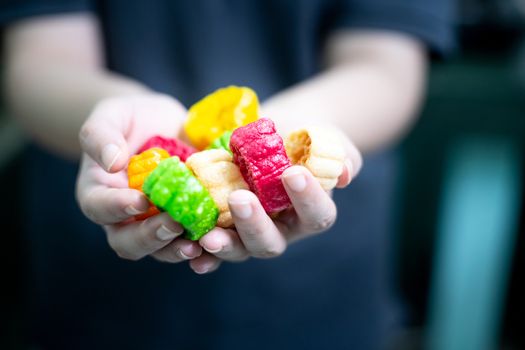 Young indian woman holding colorful fried food made of potato starch and sago called far far fryums which is a popular food in north india or a great snack. Shows an unhealthy fried snack with high empty calories that add to fat and heart disease