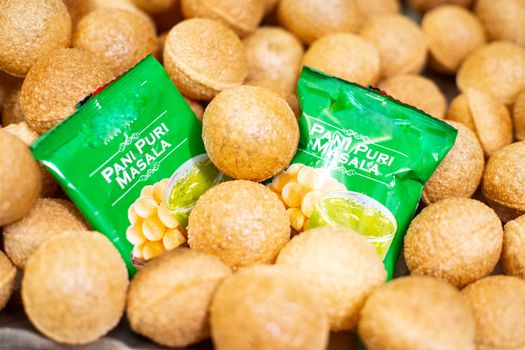 Easy to make or ready to serve gol gappe pani puri balls with green masala packets placed in the middle with chili and mint for great taste. Shows the rise of  easy to make foods in india that can be made with thi minimum of effort