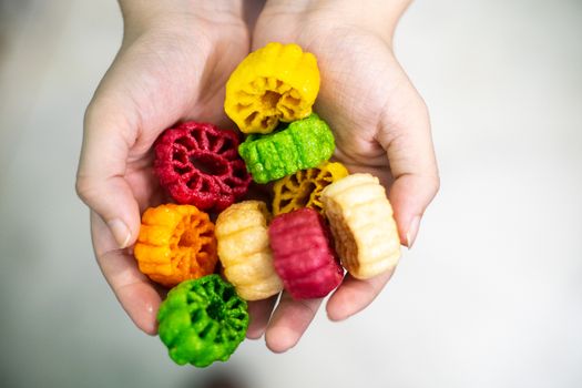 Young indian woman holding colorful fried food made of potato starch and sago called far far fryums which is a popular food in north india or a great snack. Shows an unhealthy fried snack with high empty calories that add to fat and heart disease