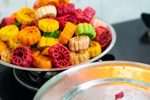 shot of colorful Fryums being deep fried in hot oil bubbling and sizzling with bubbles forming and size increasing of this popular north indian snack and street food. This sago and potato starch delicacy is a popular snack that is unhealthy but very tasty