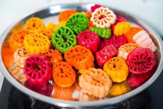 shot of colorful Fryums being deep fried in hot oil bubbling and sizzling with bubbles forming and size increasing of this popular north indian snack and street food. This sago and potato starch delicacy is a popular snack that is unhealthy but very tasty