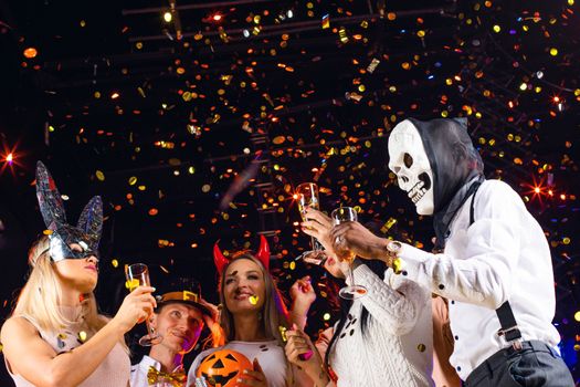 Happy people men and women mixed race dancing together on Halloween party