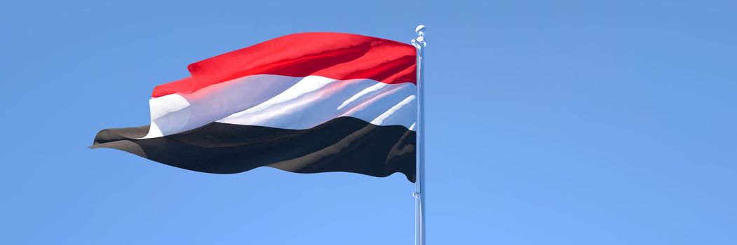 3D rendering of the national flag of Yemen waving in the wind against a blue sky