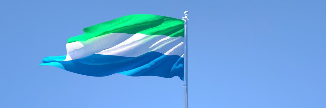 3D rendering of the national flag of Sierra Leone waving in the wind against a blue sky