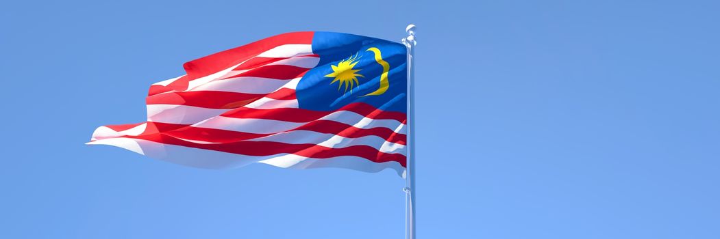 3D rendering of the national flag of Malaysia waving in the wind against a blue sky