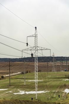 Working professionals inspect wire high-voltage power line