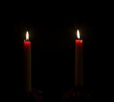 Two candles burning in the dark