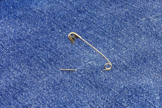 Metal pin threaded through the blue denim