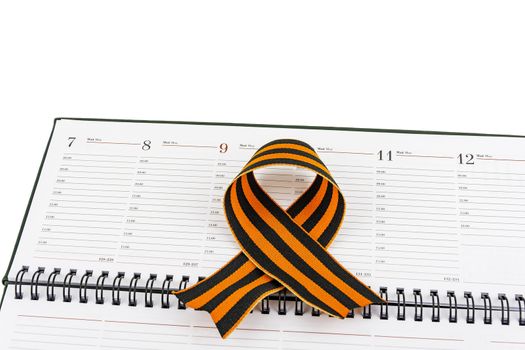 In an open diary sheet is St. George's ribbon in a bow