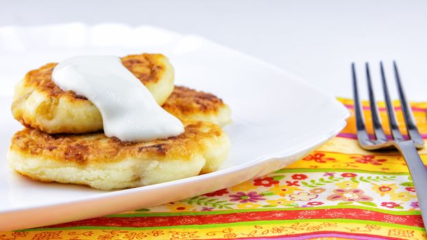 On the white plate is a dessert cheese with sour cream, fried in oil