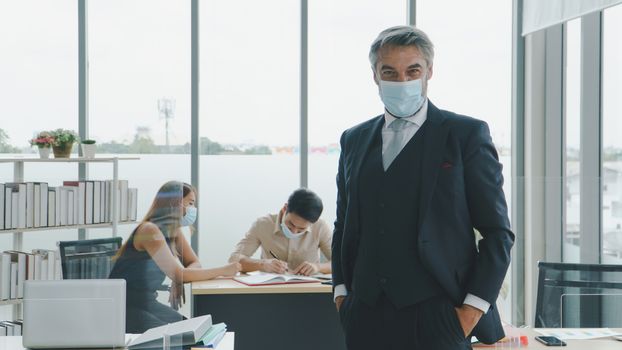 Business people wear a protective mask to work together in the company office. social distancing is the new normal. The concept of preventing the spread of coronavirus or COVID-19
