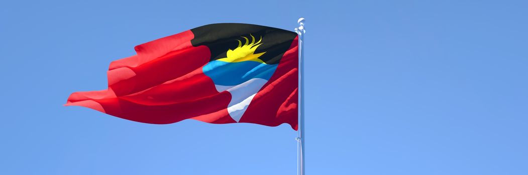 3D rendering of the national flag of Barbuda waving in the wind against a blue sky