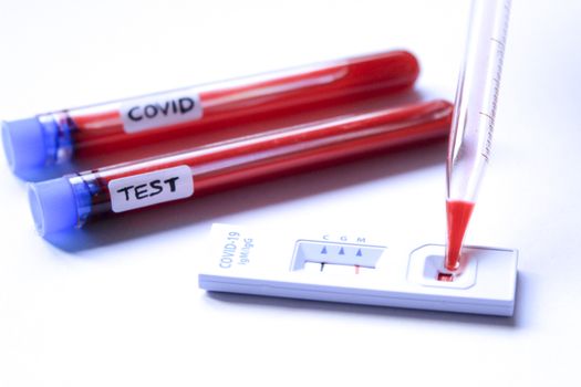 Medical worker placing blood sample on Rapid Diagnostic Test identifying antibodies for Coronavirus SARS-CoV-2 COVID-19