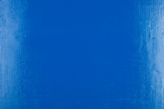 abstract flat blue painted plywood board background with vertical white reflections.