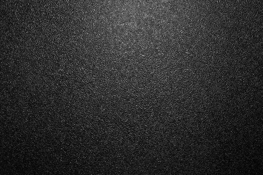 Dark full frame background of hammered powder paint coating on flat sheet steel surface. Also known as hammertone effect.