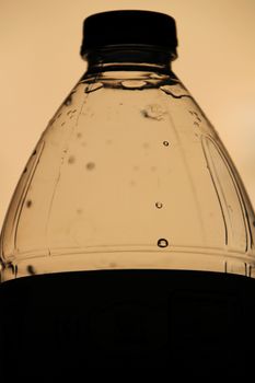 Silhouette of a plastic bottle of water. Dark picture.