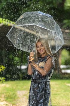 A gorgeous young blonde model poses while getting wet outdoors as she enjoys a summers day