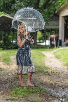 A gorgeous young blonde model poses while getting wet outdoors as she enjoys a summers day