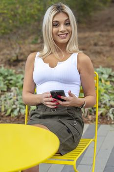 A gorgeous young blonde model poses outdoors while enjoying a summers day