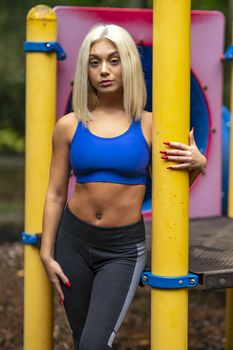 A gorgeous young blonde model works out outdoors while enjoying a summers day