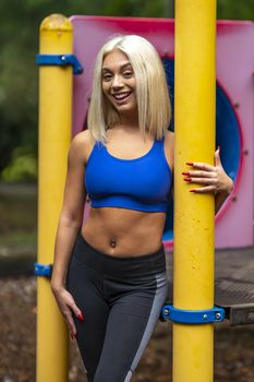 A gorgeous young blonde model works out outdoors while enjoying a summers day