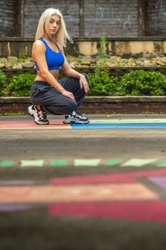 A gorgeous young blonde model works out outdoors while enjoying a summers day