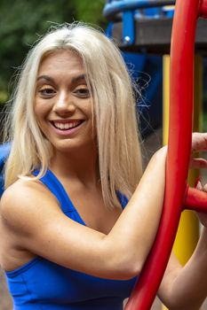 A gorgeous young blonde model works out outdoors while enjoying a summers day